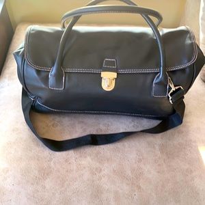 Leather carryon bag with shoulder strap and pink material inside